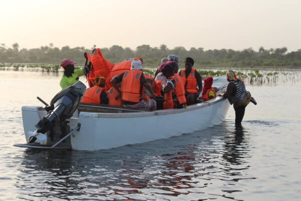 Photo des femmes villageoises de Danna, en bateau pour un projet de reforestation de la mangrove